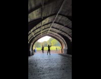 Man playing flute inside tunnel at park