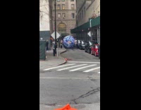 Collab WINY - Men roll huge inflatable earth ball on street