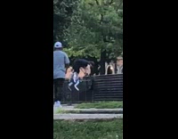 Guy holds fence bounces white shoes stilts 