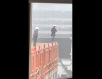 Man no protection stands on building edge 