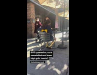 Girl blue sweater gold boots typewriter sidewalk 