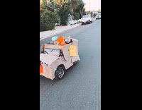 Two kids ride toy car in costume