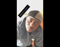 Guy stares at the camera  while standing in the kitchen