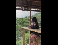 Hummingbird flies on the feeder near the woman with coffee