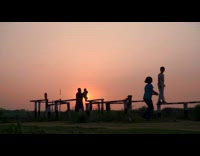 Kids and father play on railings sunset
