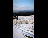 White Helmet Rides Four Wheeler on Snow Turns It over