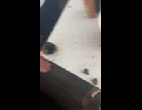 Girl tries to cut burnt black baked potato 