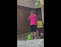 Kid sprays toddler with garden hose water