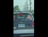 Car driving on the road with two large anime stickers on rear window