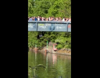 Person climbing through underneath crowded bridge