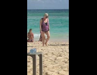 Woman black bikini takes picture at beach