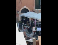 woman sitting on bench venice canals background