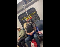 Woman sits on man inside subway train