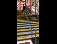 Boy slides down staircase hand rail and falls backwards