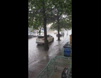 Cars pass by street with flood
