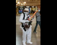 Guy in white plays inaudible electric guitar 