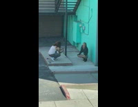 Girl black jacket sit beside blue wall