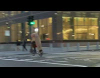 Guy wearing cardboard box rides bicycle 