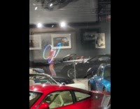 Woman with lit hula-hoops at car show