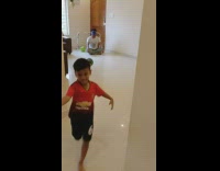 Little boy aims ball over head 