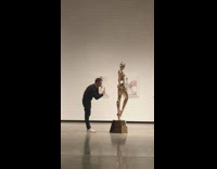 Guy photographs gold statue butt art museum 