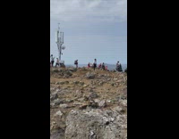 Woman turquoise top attempts to do a handstand