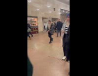 Men in green cloaks marching through grand central station