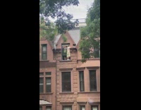Two guys hang out top story window