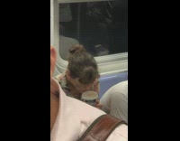 Woman eats pint of ice cream without spoon and with mouth on subway train