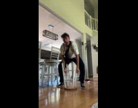 Man spins on flipped stool chair