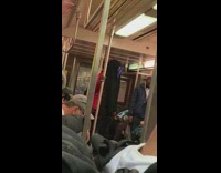 Person wears colorful LED mask on subway