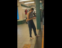 Man waits for train with bag on head 