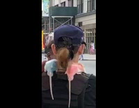 Woman dyes rats blue purple pink and lets them sit on her shoulder on sidewalk