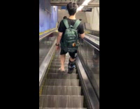 Man with leg cast brace goes down broken escalator