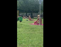 Pink bikini girl sits grass selfie stick 