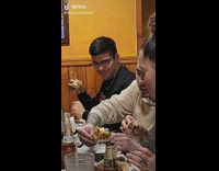 Guy licks fingers while eating and stares at camera