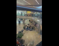 Two men carry two women on their shoulder in the mall