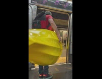 Guy carries yellow kayak off subway 