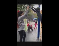 Girl spins with little kid on wheel and he falls cries