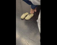Person riding subway touches ground with bare feet