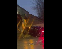 Black car seen stuck on road column 