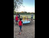 Kid hangs on roundabout hits another kid