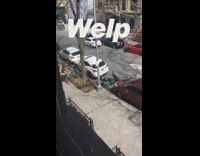 Two guys play sousaphone instrument down sidewalk 