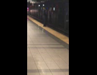 Man stands very close to the edge of subway platform and almost gets hit by incoming train