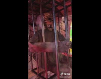 Guy puts on burnt skin mask in halloween decoration tunnel