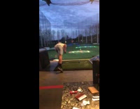 Guy wets hands, hits golf ball, and throws golf club into the air