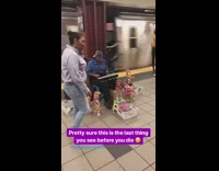 Guy blue shirt playing xylophone with a bunch of dancing dolls around him