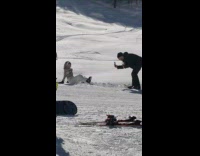 Woman sits and raises feet on the snowy ground