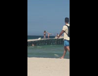 Woman in bikini does handstand on pier for photos 