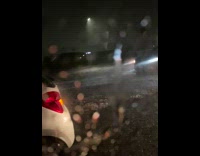 White car tries to drive through deep flood 